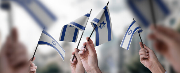 A group of people holding small flags of the Israel in their hands