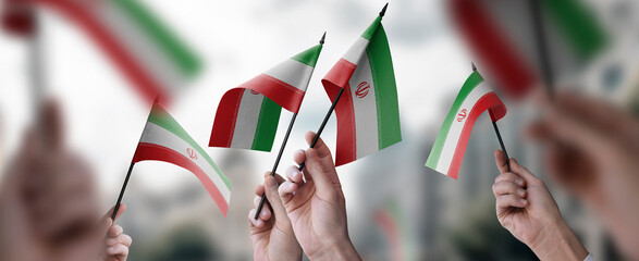 A group of people holding small flags of the Iran in their hands