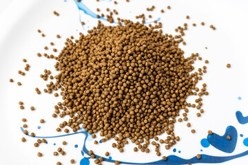 Animal feed for all kind of fish closeup with white background. The Feed for catfish at the end of...