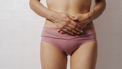 Young Asian woman wearing panties sexy slim body with lower abdominal pain or menstrual pain, real...