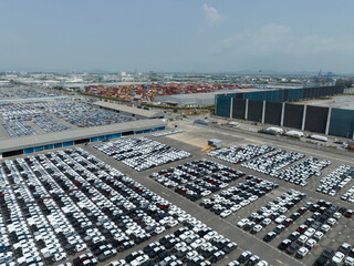 Aerial view of new cars stock at factory parking lot. Above view cars parked in a row. Automotive...