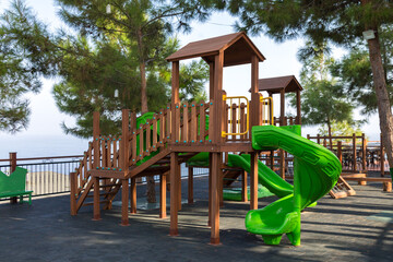 Fototapeta na wymiar Wooden children's house with a slide playground.