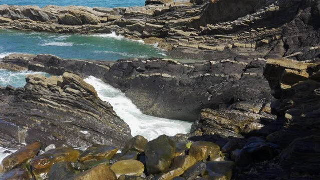 Waves crashing against oddly shaped rock formations off the north coast of Asturias, Spain.