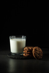 A glass with milk and chocolate cookies