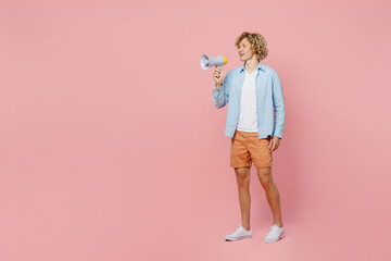 Full body young blond man wear blue shirt white t-shirt hold in hand megaphone scream announce discounts sale Hurry up isolated on plain pastel light pink background studio portrait Lifestyle concept