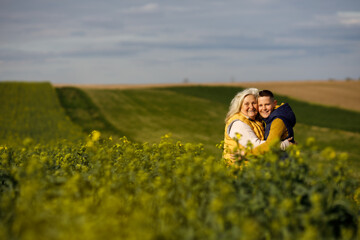 Portrait of a smiling grandmother and grandson hugging near a field