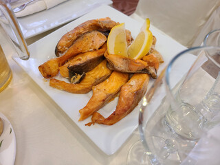 Grilled salmon with lemon on a white plate