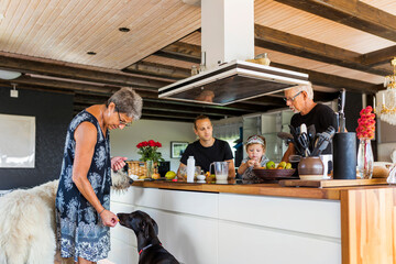 Grandparents preparing food with granddaughter (2-3)