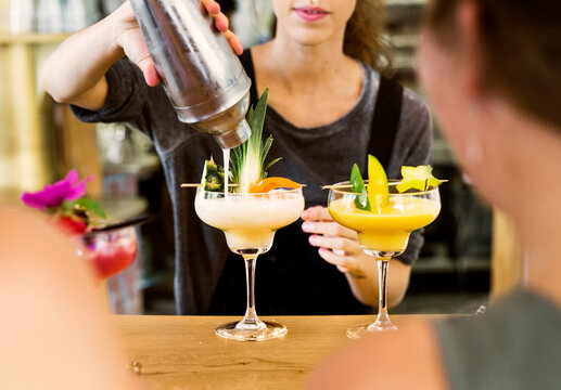 Mid section of bartender preparing colorful cocktails - Powered by Adobe