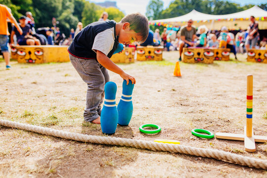 Boy playing with bowling pin at festival