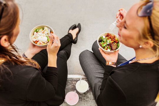 High angle view of two women eating salad
