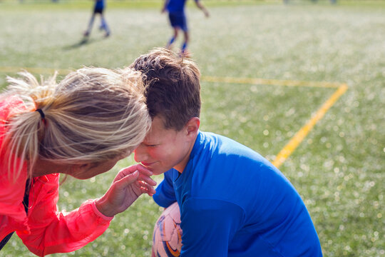 Mother comforting son (12-13) during soccer practice