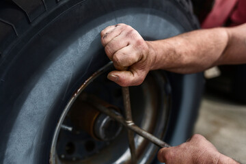Hands of mature man repairing car