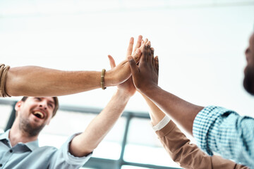 Way to go, team. a group of businesspeople high fiving each other in an office.