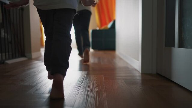 children running around the house playing silhouette. happy family kid dream concept. kids feet running back view indoors light from dream window. children run and play. brother lifestyle sister run
