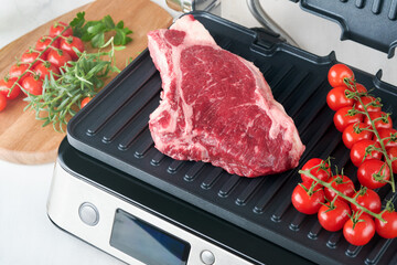 Raw prime steaks on electric grill. Black angus prime meat steaks Ribeye on modern electric grill...