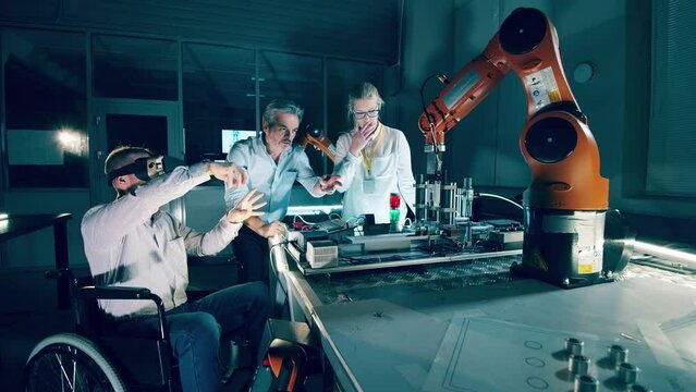 Group of engineers researching a robot using VR, disabled engineer in wheelchair