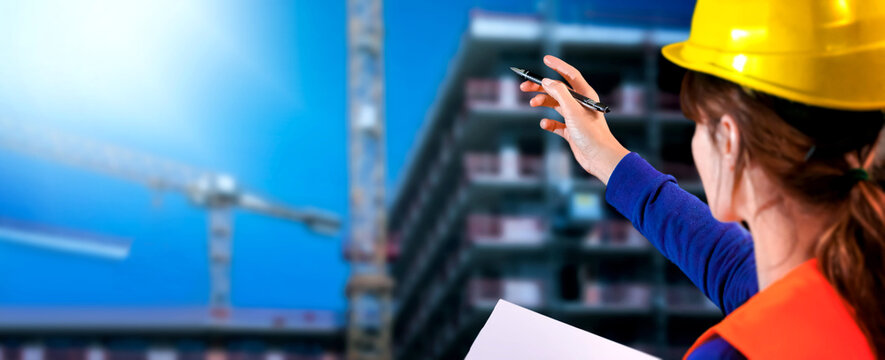 Construction worker. hand of worker with yellow hard-hat on constraction background. Helmet in construction	

