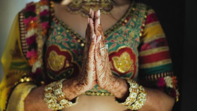 Namaste sign. Joined palms of an Indian bride close up. Indian Bride's outfit and jewelry