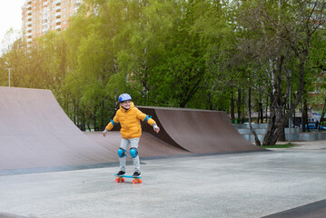 a child rides a blue city cruiser, a plastic bright skateboard, in a skate park on a halfpipe	