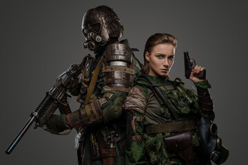 Shot of two military people together with pistol and shotgun against grey background.