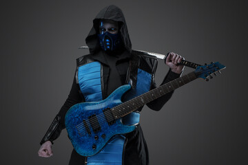 Shot of stealth assassin with guitar and katana looking to side.