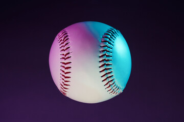 Glow of neon lights on baseball closeup for modern pop art style ball used in sport.