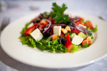 Greek salad in a white plate. Healthy food. Mediterranean Kitchen.