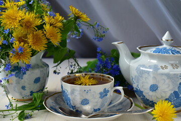 still life with tea and dandelions in a porcelain service