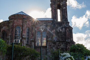 Contrast of the facade of the Chapel of Our Lady of Victories in low light with stained glass windows and sun rays in Furnas, S&atilde;o Miguel - Azores PORTUGAL