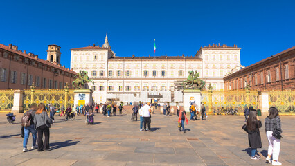 Obraz premium Royal Palace next to Piazza Castello crowded with people on a sunny spring afternoon