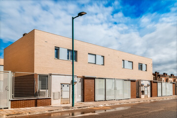 New single-family townhouses built in brick in the outskirts of a city. Marchamalo, Guadalajara. Real estate, sustainable construction and investment concepts.