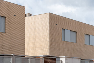 New single-family townhouses built in brick in the outskirts of a city. Marchamalo, Guadalajara. Real estate, sustainable construction and investment concepts.