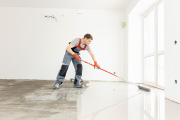 Worker use screed concrete epoxy for level. Leveling with mixture of cement for floors