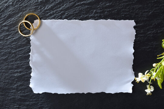 Slate stone background for marriage announcement with rings and flowers