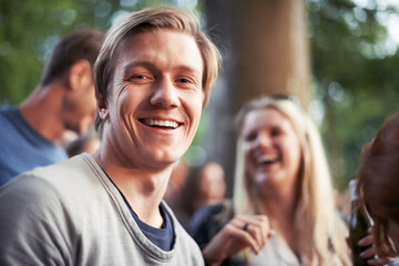 Enjoy an outdoor event. Portrait of a happy young man enjoying an outdoor festival with his friends.