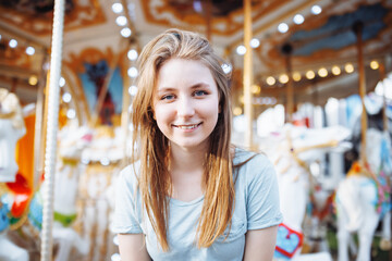 Happy young Gen Z woman in amusement park, smiling