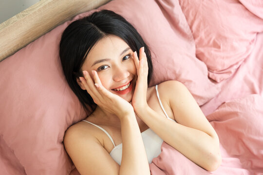 Portrait of a beautiful and playful asian girl in bed in the morning
