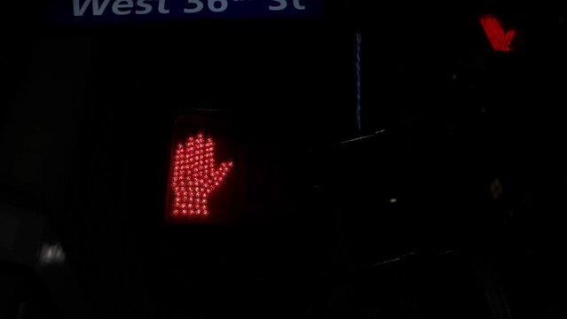 View of city night with red traffic light signal for pedestrians in form of hand, counting down rest of waiting time. New York. USA.