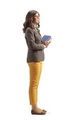 Full length profile shot of a young woman in formal clothing holding books