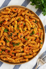Homemade Creamy Tomato Shrimp Rotini Pasta with Parsley on a Plate, top view. Flat lay, overhead, from above. Close-up.
