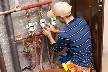 The technician checking the heating system with tablet in hand