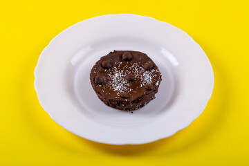 Chocolate cheese pie on a plate on a yellow background