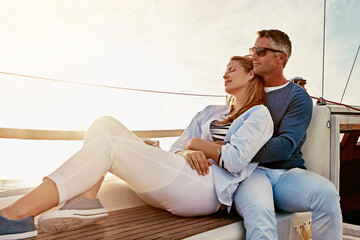 Love is keeping your marriage on honeymoon. a couple enjoying a boat cruise out on the ocean.