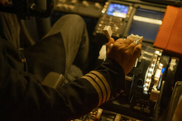 Close-up of the pilot's hand on the engine control stick. 