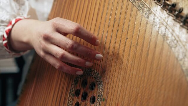Woman playing on old traditional ukrainian stringed instrument bandura or kobza