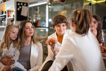 Diverse schoolchildren with teacher work together on science project