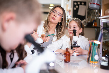 Group of children with microscope in the laboratory