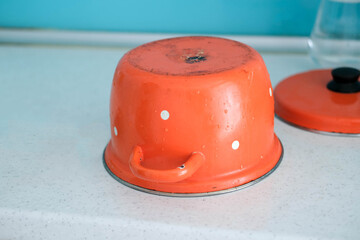 Fototapeta premium Dirty red saucepan on the countertop.