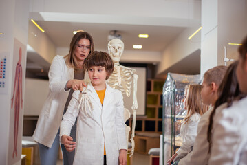 Young woman teaches class on human bone structure
